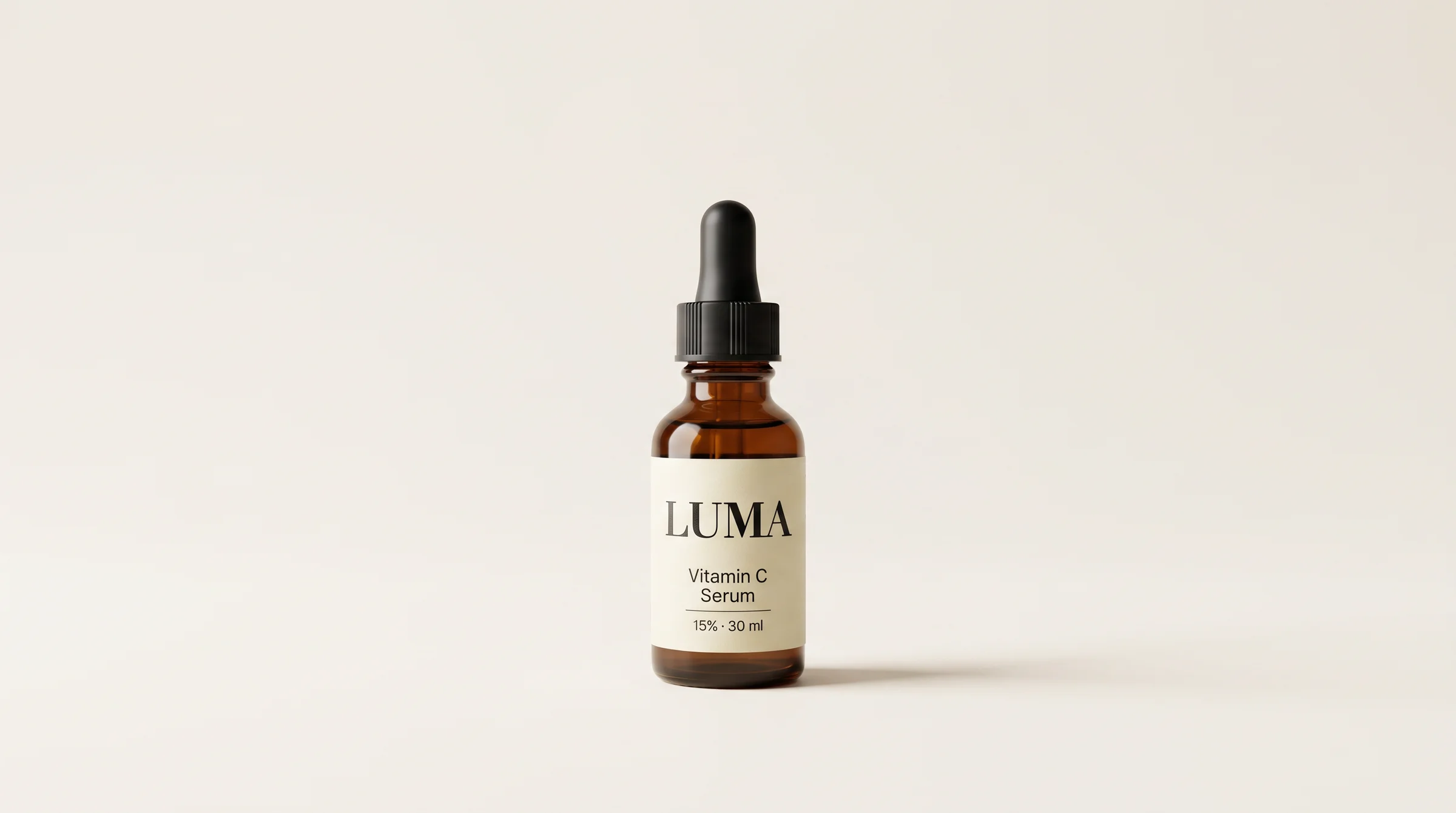 LUMA Vitamin C serum in an amber dropper bottle, photographed in a warm neutral studio